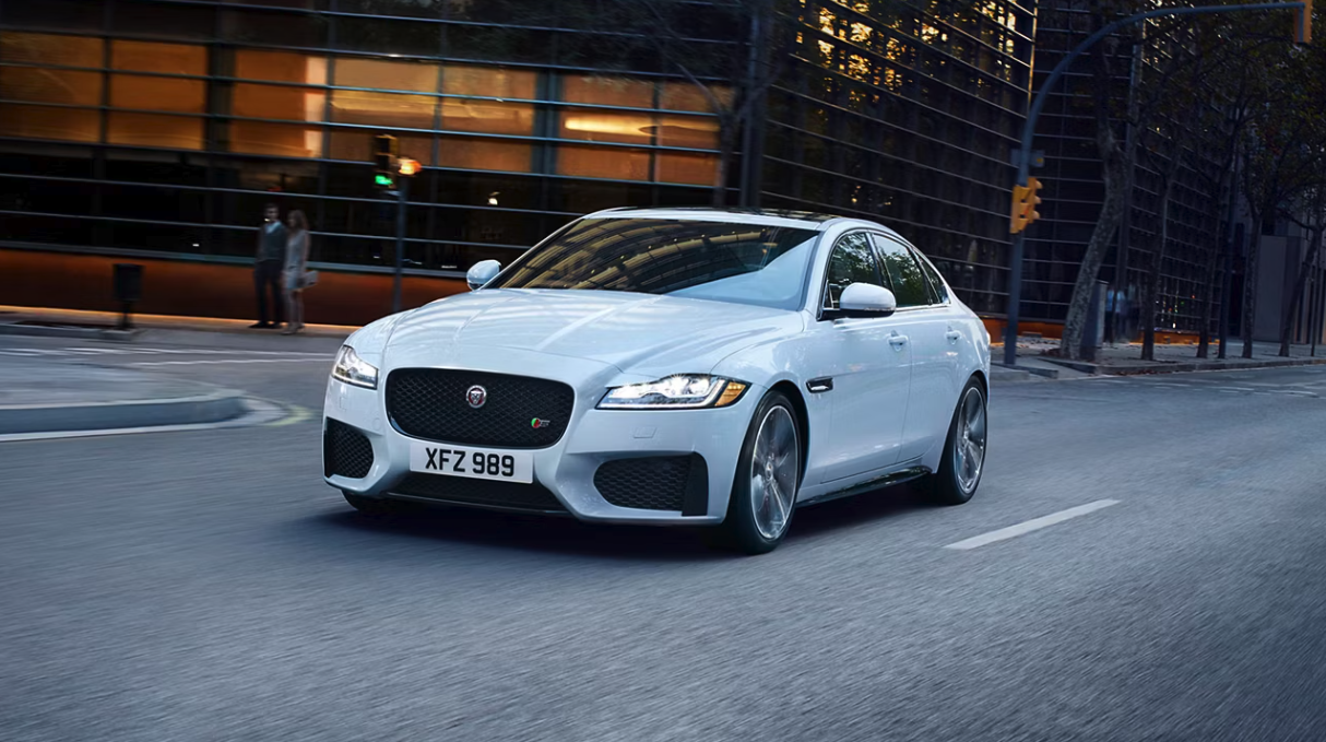Why buy certified pre-owned inventory Front view of a Jaguar XF on a city road
