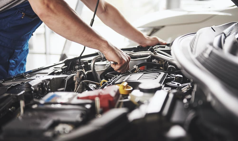 A service technician working on a vehicle engine