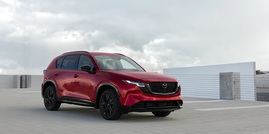 A red Mazda CX-5 parked at the top of a parking garage.