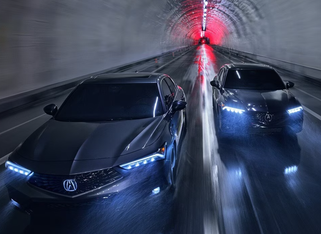 Two dark gray 2024 Acura Integra cars speeding through a tunnel