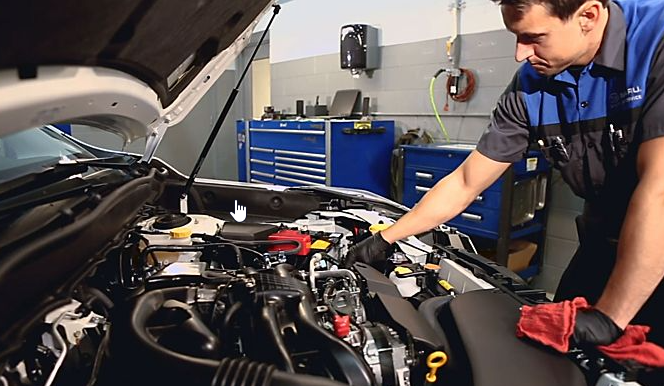 A trained mechanic looks under the hood of a subaru