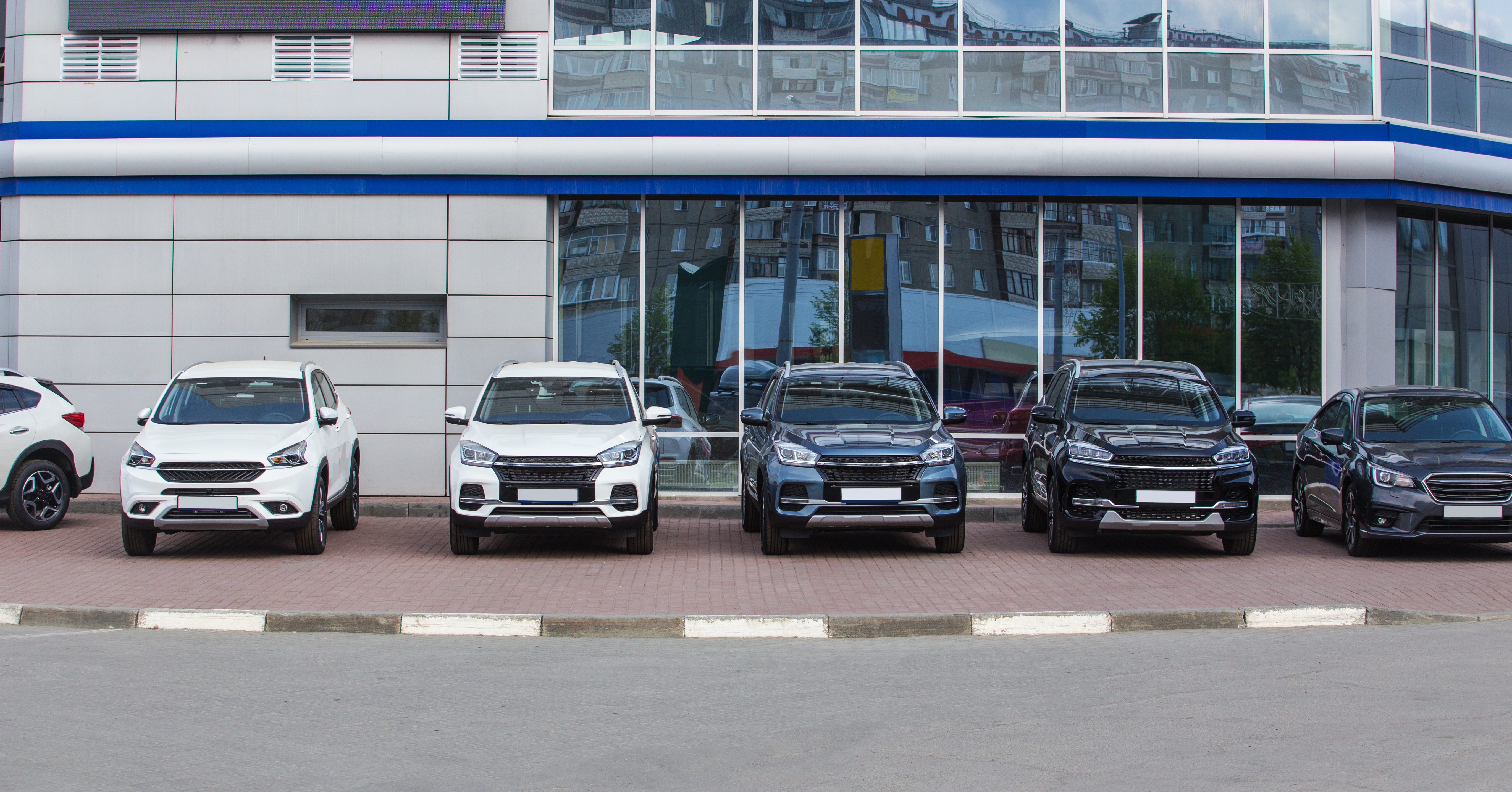A row of SUVs in a car dealership parking lot